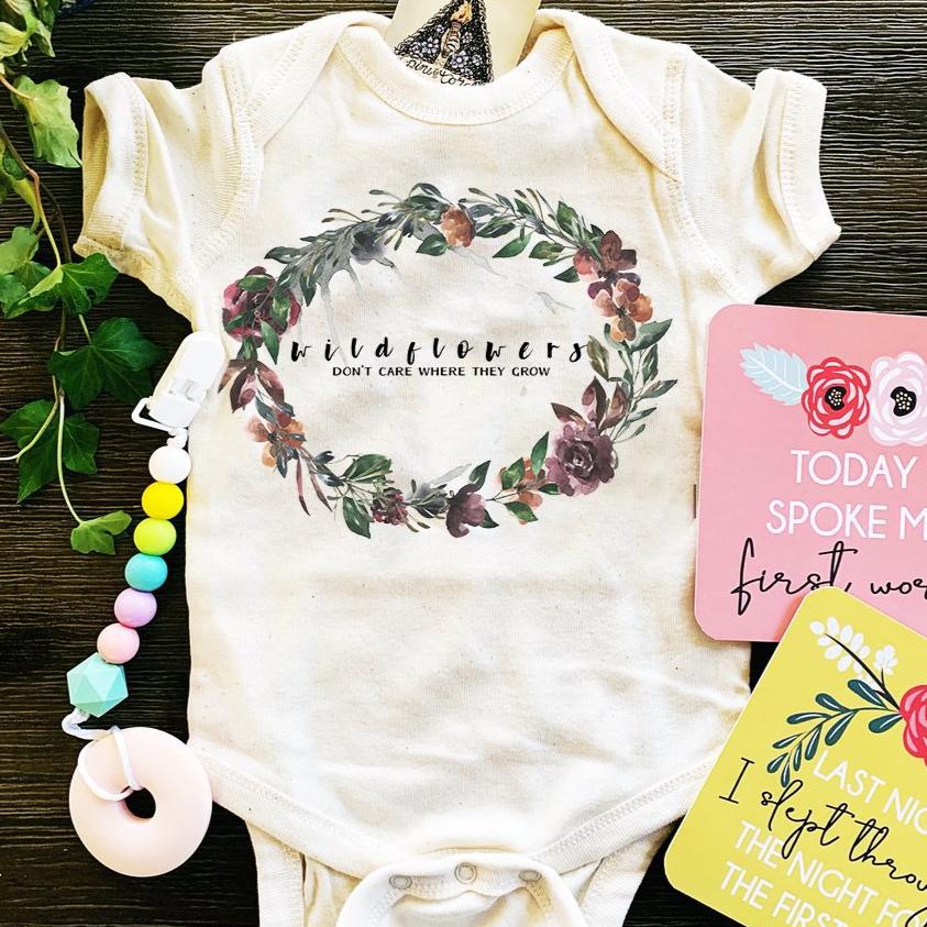 « WILDFLOWERS DON'T CARE WHERE THEY GROW » BODYSUIT